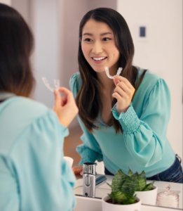 Girl Smiling Infront Mirror with Invisalign